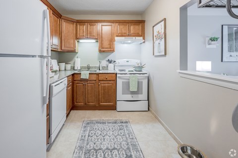 A kitchen with wooden cabinets and a white refrigerator.